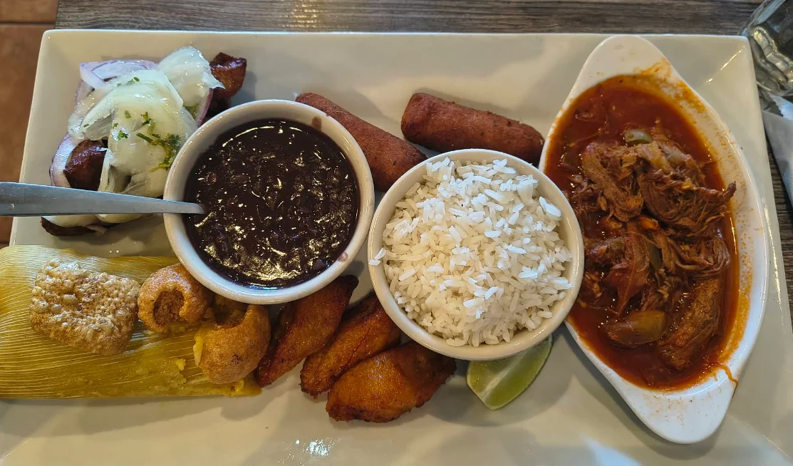 Plato cubano con ropa vieja, tamal, tostones, frijoles negros y arroz en Casa Juan Miami.