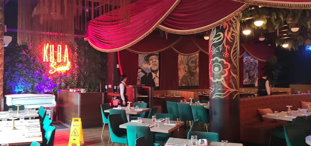 Salón de Kuba Cabana con cortinas de terciopelo rojo y letrero de neón en CityPlace Doral.