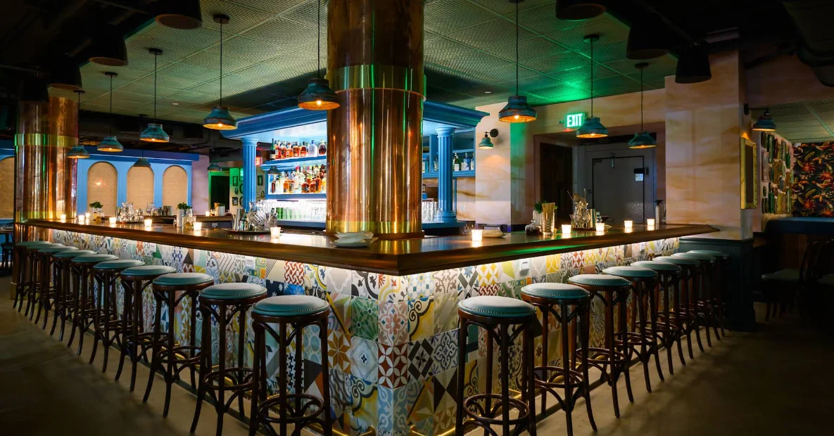 Barra de cócteles con azulejos y columnas de cobre en La Cañita Beach, Ocean Drive Miami.